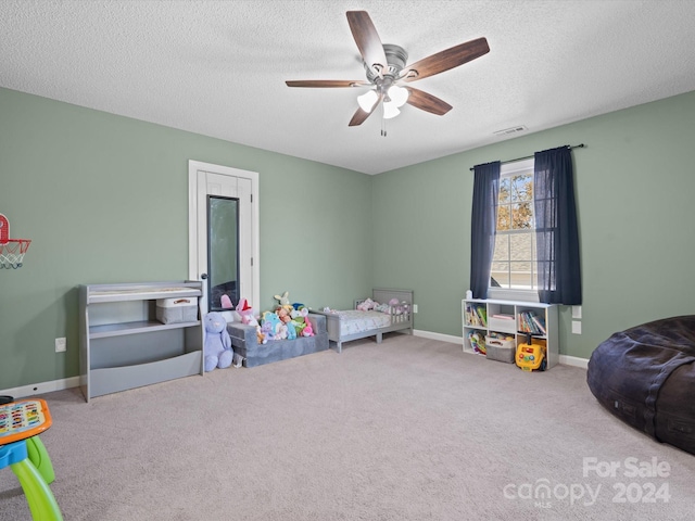 rec room with ceiling fan, a textured ceiling, and carpet floors