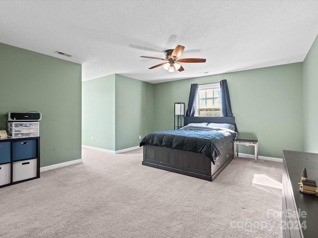 bedroom with light carpet, a textured ceiling, and ceiling fan