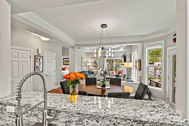 dining space with an inviting chandelier, sink, hardwood / wood-style flooring, and ornamental molding