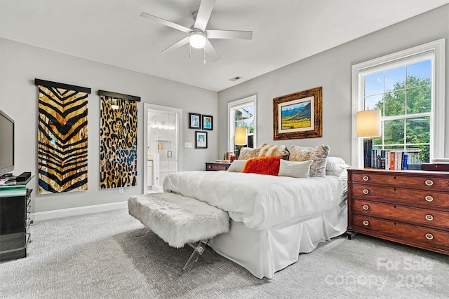 bedroom with light carpet, ceiling fan, and ensuite bathroom