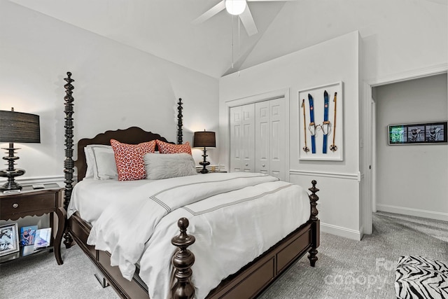 bedroom featuring a closet, vaulted ceiling, light carpet, and ceiling fan