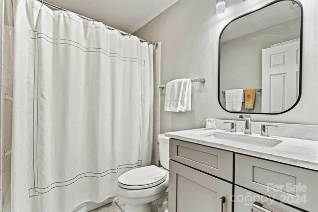 bathroom with walk in shower, vanity, and toilet