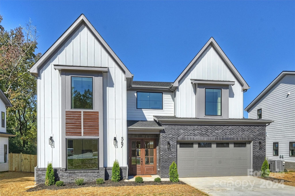 modern inspired farmhouse with central air condition unit and a garage