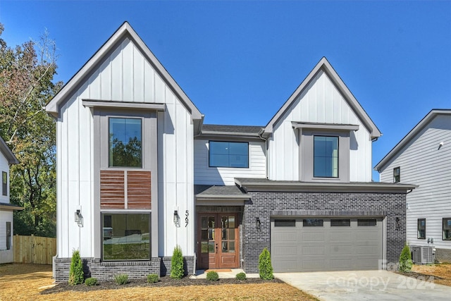 modern inspired farmhouse with central air condition unit and a garage