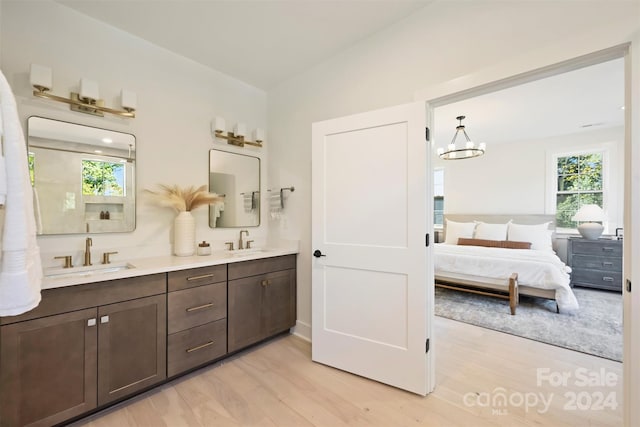 bathroom featuring lofted ceiling, vanity, an inviting chandelier, and hardwood / wood-style flooring