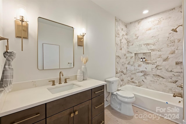 full bathroom with toilet, tiled shower / bath combo, vanity, and hardwood / wood-style flooring