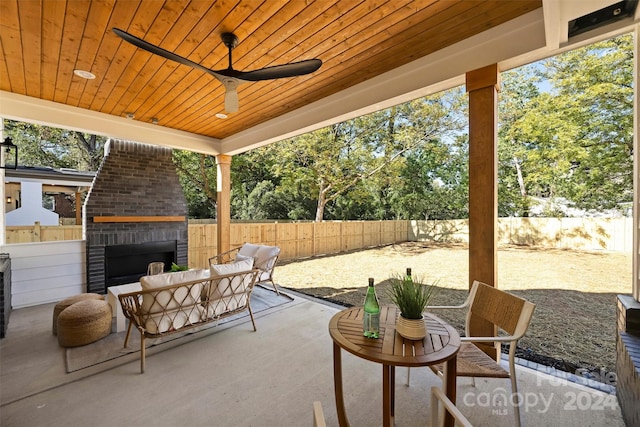 view of patio with ceiling fan and an outdoor brick fireplace