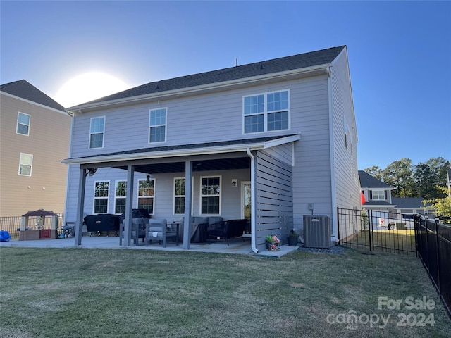 rear view of property with a yard, cooling unit, and a patio