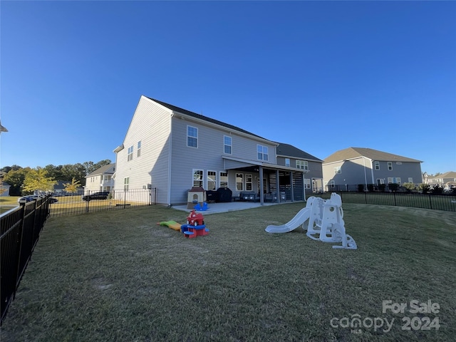 back of property with a patio area and a lawn