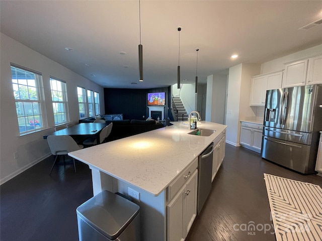 kitchen featuring a kitchen island with sink, sink, white cabinetry, and stainless steel appliances