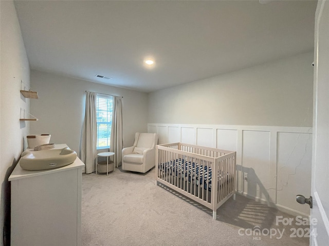 carpeted bedroom featuring a crib