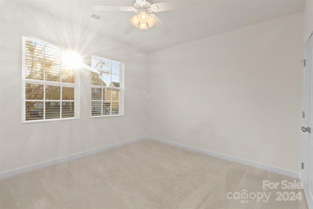 unfurnished room featuring ceiling fan and light colored carpet