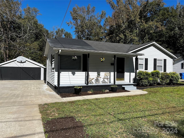 ranch-style home with a front lawn, a porch, an outbuilding, and a garage