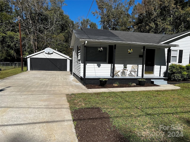 view of front of property with covered porch, a garage, a front lawn, and an outdoor structure