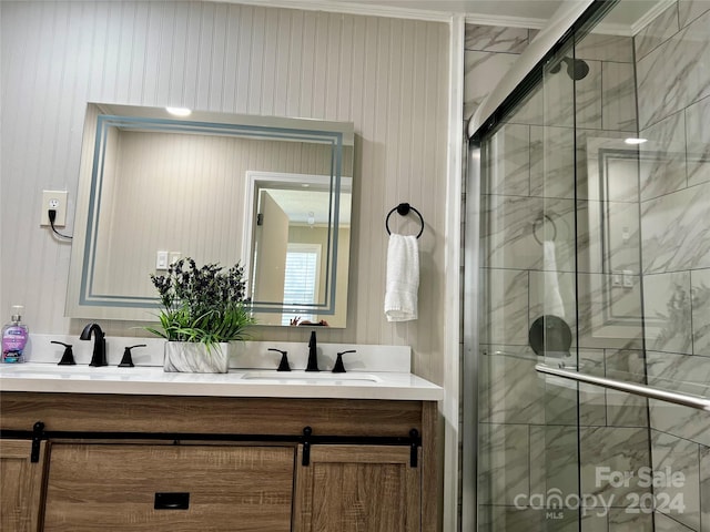 bathroom featuring vanity, ornamental molding, and an enclosed shower