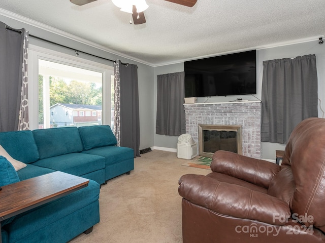 carpeted living room featuring ceiling fan, ornamental molding, a textured ceiling, and a brick fireplace