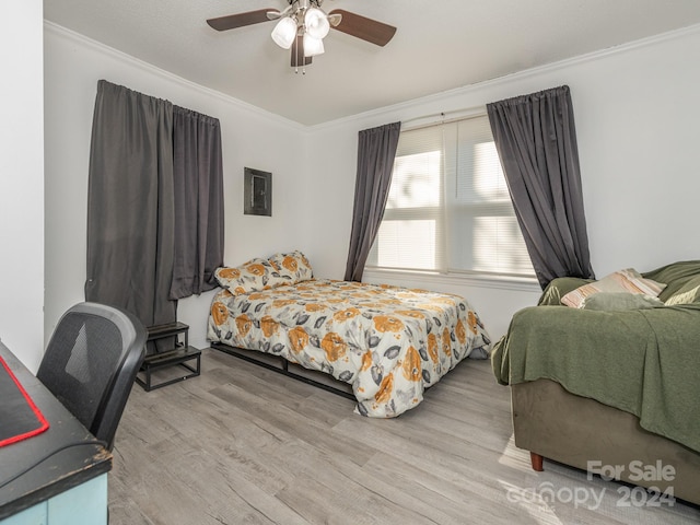 bedroom featuring light hardwood / wood-style floors, ceiling fan, and ornamental molding