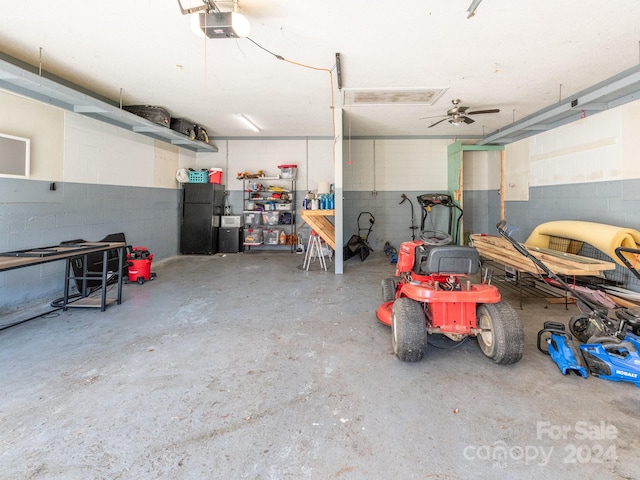 garage with black fridge, ceiling fan, and a garage door opener