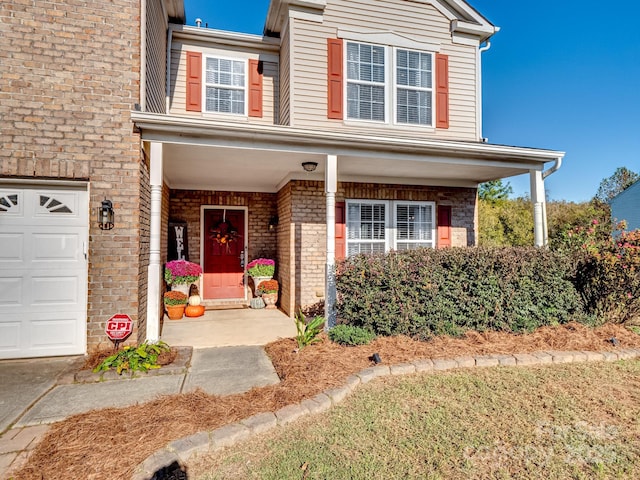 townhome / multi-family property with a garage and a porch