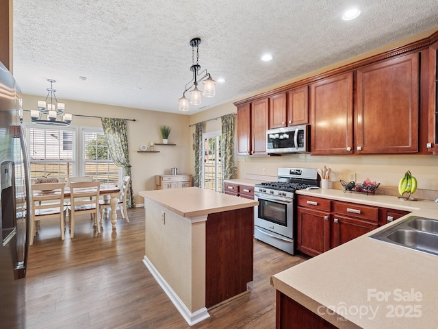 kitchen with stainless steel appliances, a kitchen island, hanging light fixtures, and dark hardwood / wood-style floors