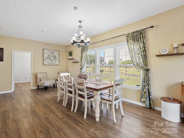 dining space with dark wood-type flooring, a textured ceiling, and a notable chandelier