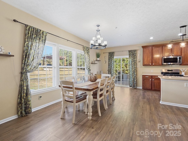 dining room with dark hardwood / wood-style flooring, a healthy amount of sunlight, and an inviting chandelier