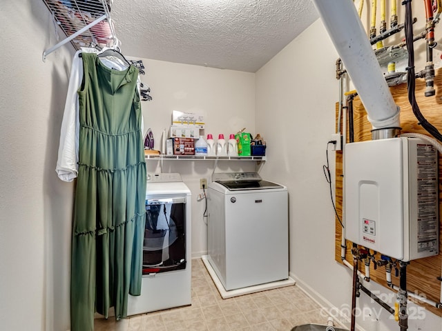 laundry area featuring tankless water heater, washer and dryer, and a textured ceiling