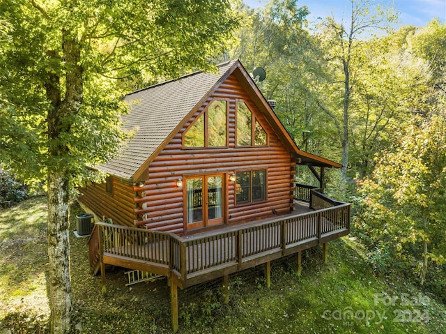 rear view of property with a wooden deck and cooling unit