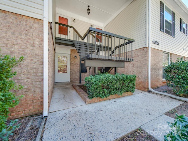 view of exterior entry with a patio area