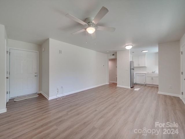 unfurnished living room with sink, ceiling fan, and light hardwood / wood-style flooring