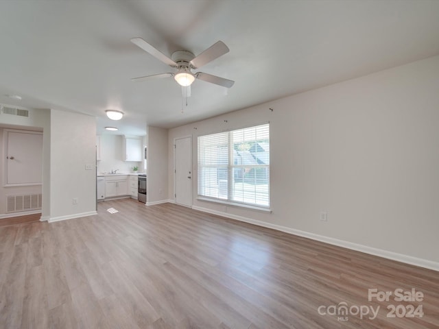 unfurnished living room with light hardwood / wood-style flooring and ceiling fan