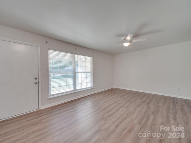 empty room with ceiling fan and light hardwood / wood-style flooring