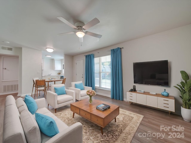 living room featuring hardwood / wood-style floors and ceiling fan