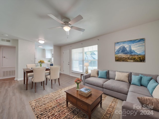 living room featuring wood-type flooring and ceiling fan