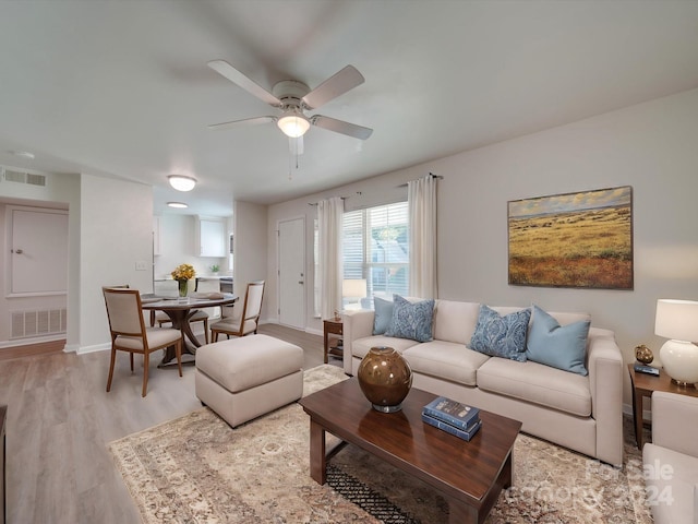 living room with light wood-type flooring and ceiling fan