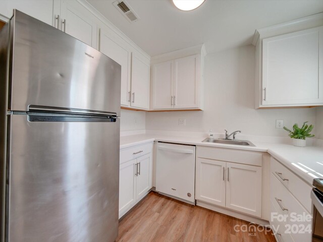 4605 Coronado Dr Unit M, Charlotte, NC 28212 - kitchen featuring white dishwasher, a sink, light wood-style floors, freestanding refrigerator, and visible vents