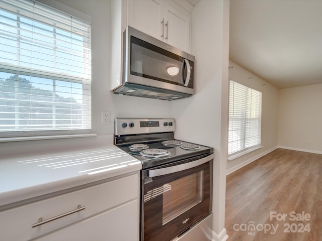 kitchen featuring appliances with stainless steel finishes, light hardwood / wood-style flooring, and white cabinetry