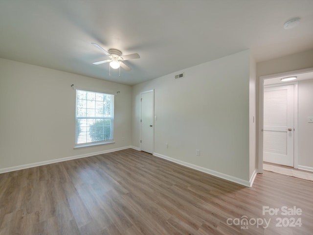 spare room with light wood-type flooring and ceiling fan