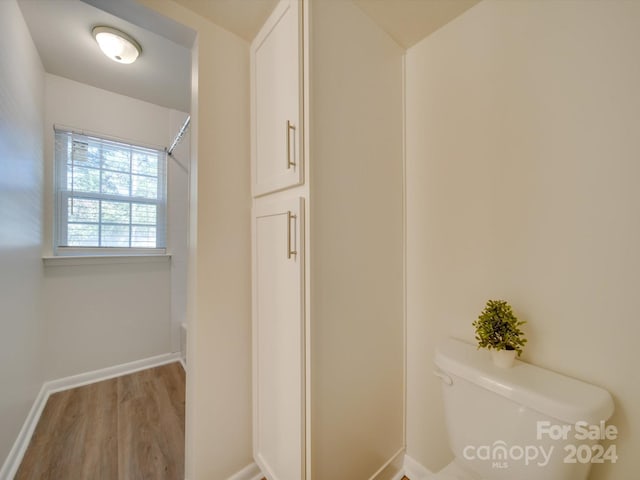 bathroom with wood-type flooring and toilet