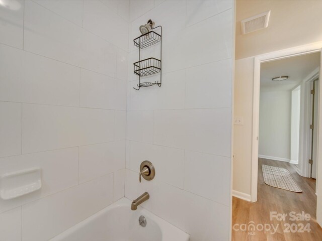 bathroom featuring tiled shower / bath combo and hardwood / wood-style flooring