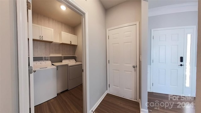 laundry room featuring crown molding, cabinets, washer and clothes dryer, and dark hardwood / wood-style flooring