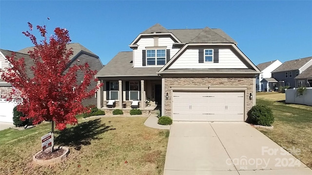 view of front of property with covered porch, a front yard, and a garage