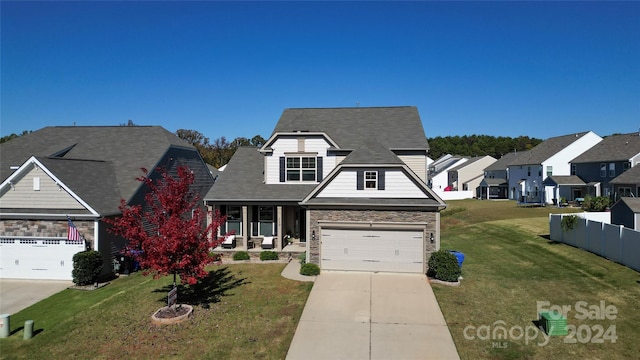 view of front facade featuring a garage, a front lawn, and a porch