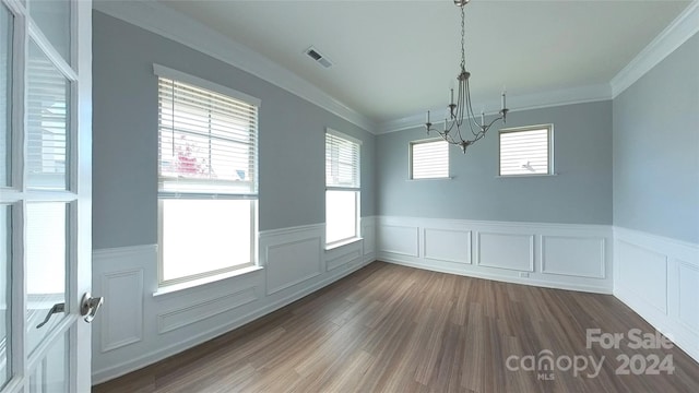 unfurnished dining area featuring ornamental molding, plenty of natural light, and dark hardwood / wood-style flooring