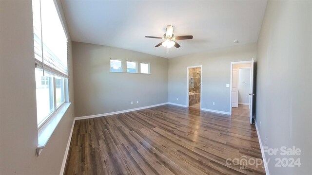 spare room with wood-type flooring, a healthy amount of sunlight, and ceiling fan