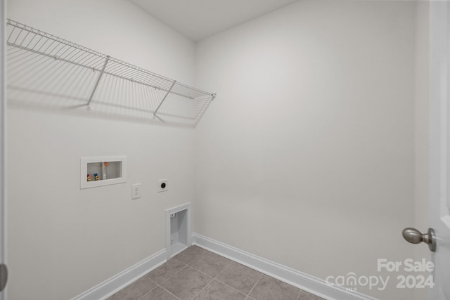 washroom featuring hookup for an electric dryer, hookup for a washing machine, and light tile patterned floors