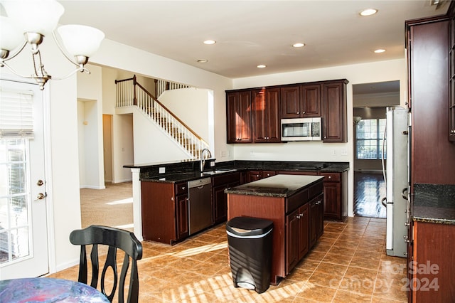 kitchen with a center island, a wealth of natural light, sink, and stainless steel appliances