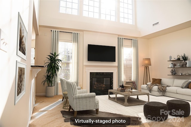 carpeted living room with a towering ceiling