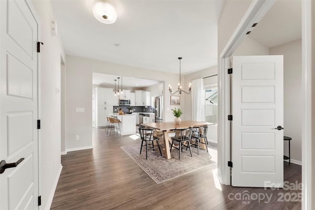 dining area featuring dark hardwood / wood-style flooring and a notable chandelier