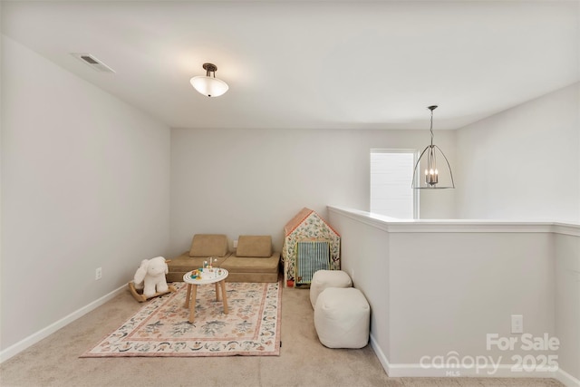 sitting room with light carpet and a notable chandelier